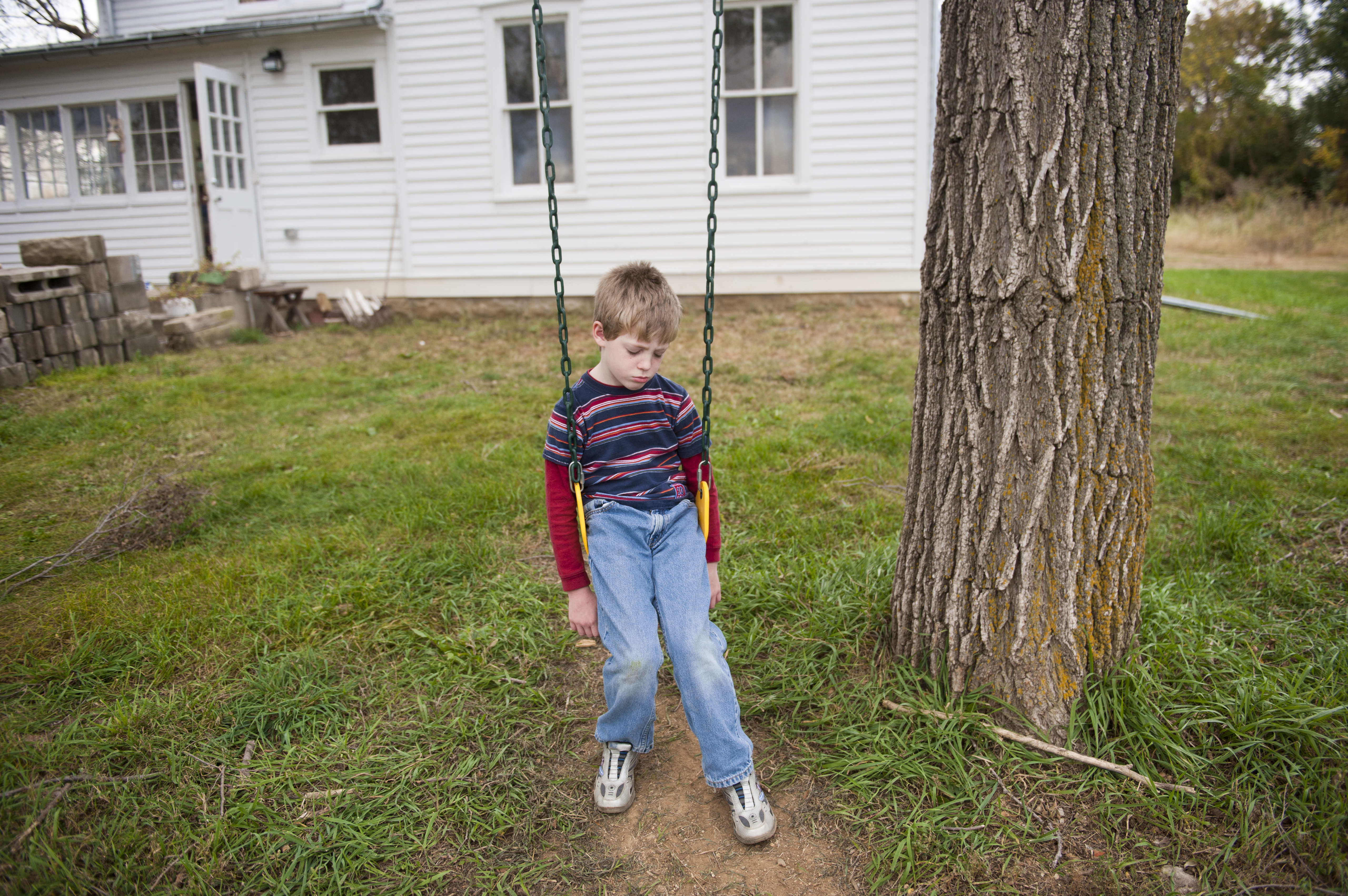 A young boy pouts on a swing in Dunbar, NE.