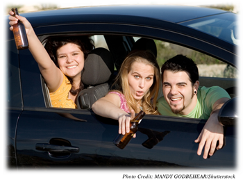 Teens laughing, smiling, and holding beers while in a car