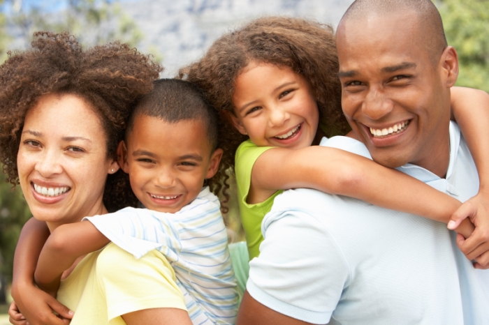 nuclear family: family of four smiling and hugging each other