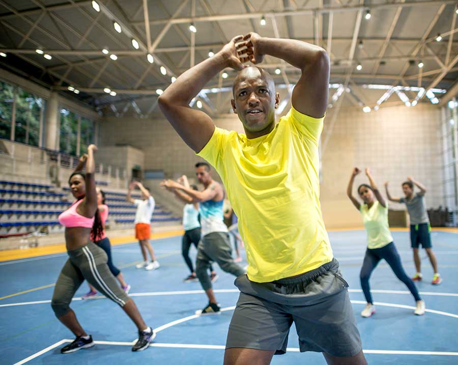 Photo: young adults engaging in aerobic exercise (running or using gym equipment)