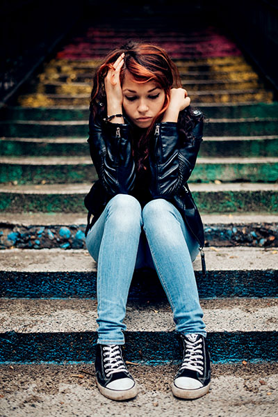Photo: Depressed teenager sitting lonely outdoors