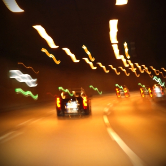 A night view of cars moving in a tunnel road.