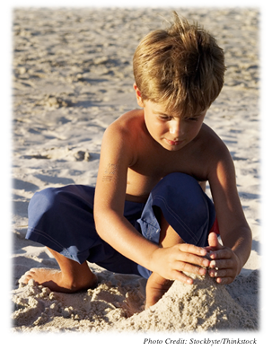 A young boy building a sand castle  
