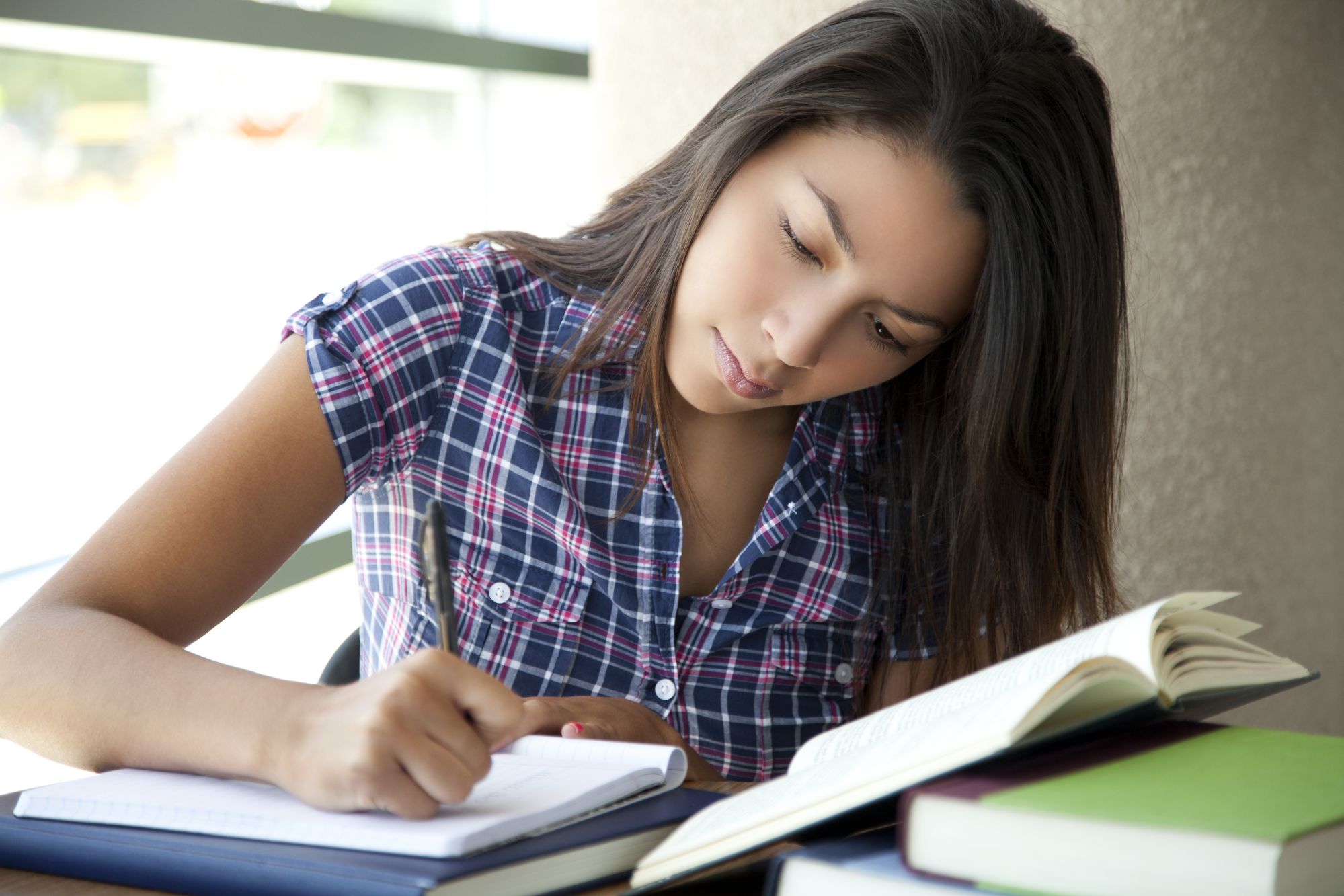 a young adult female studying a textbook 