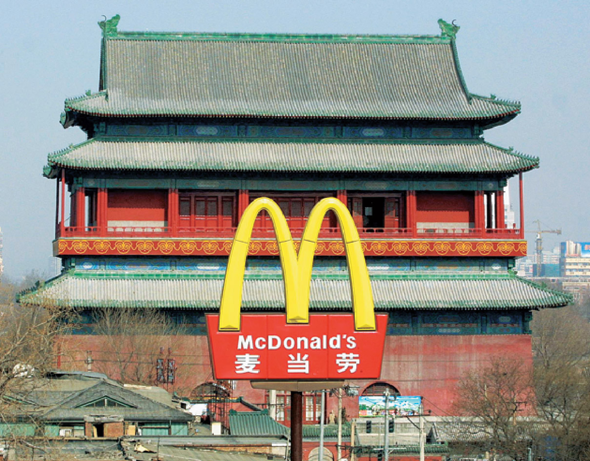 A photo shows McDonalds logo in China. The name board has the brang logo with the brand name  Mc Donalds written in english and Chinese. 