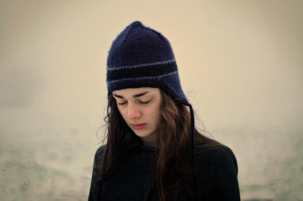 Photo shows a girl wearing winter clothes and looking depressed, which may indicate that depression is more frequently observed during winter. 