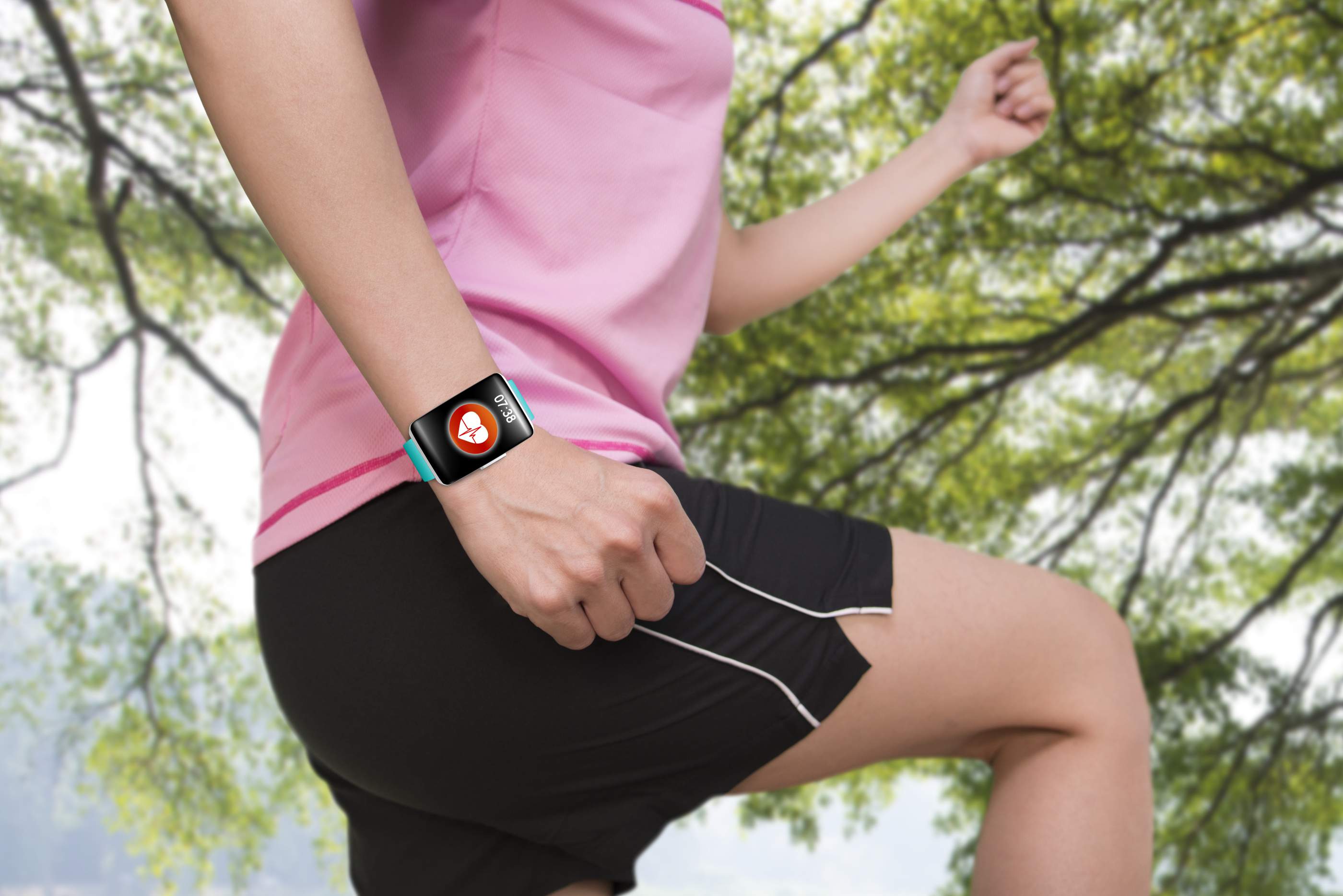 A woman wears a wearable activity tracker as she performs physical activity to monitor her fitness level. 