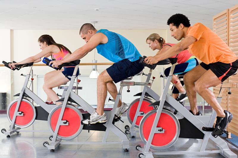 photo of people exercising in a fitness room—such as on a stationary bike