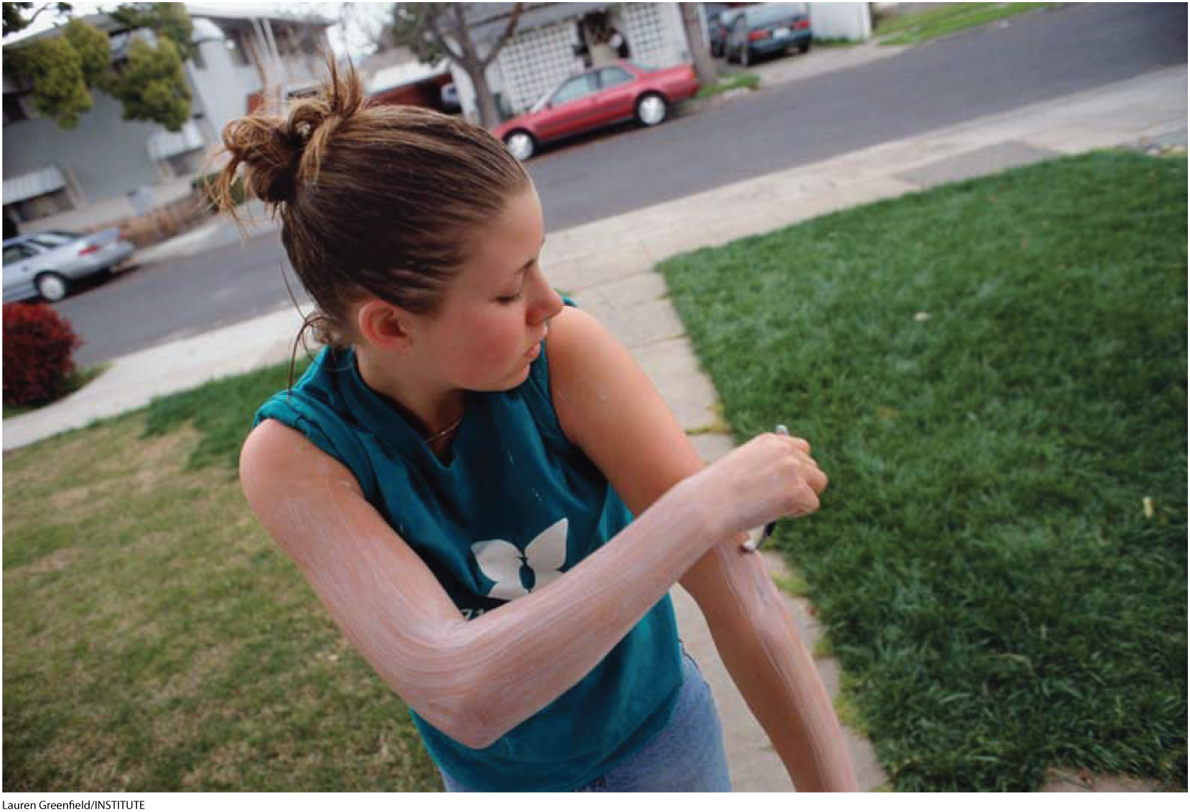 A photo shows a girl shaving her arms.