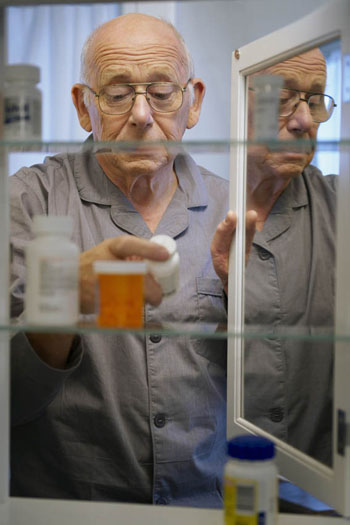 senior man holding medicine bottle