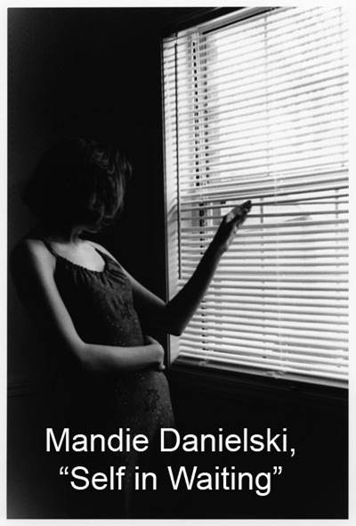 Black-and-white photo of a woman peeking through window blinds. The photographer’s name, Mandie Danielski, appears at the bottom with the title, Self in Waiting. 