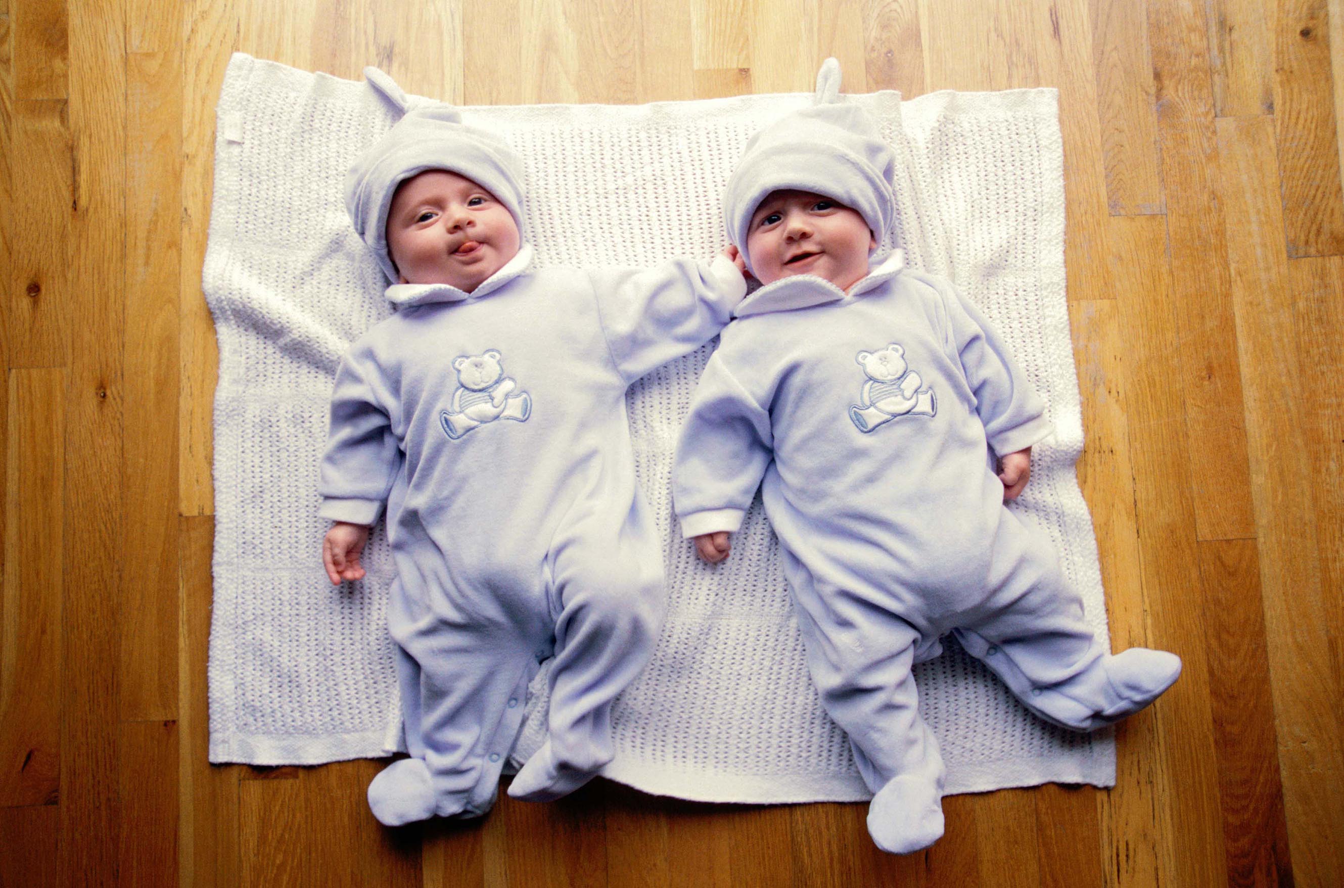 High angle view of a set of twin babies lying on a blanket