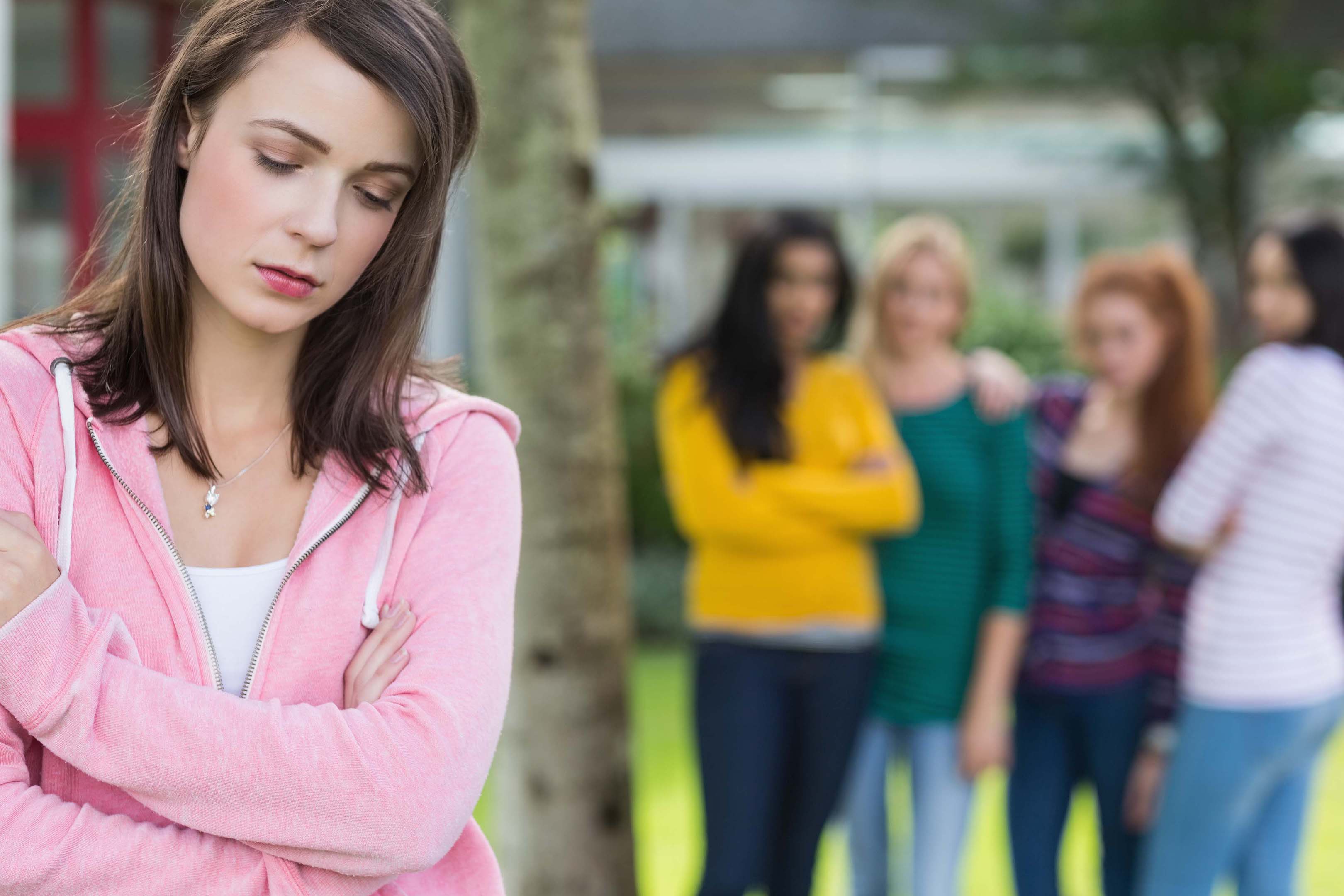 Young woman student appears bullied by other female students