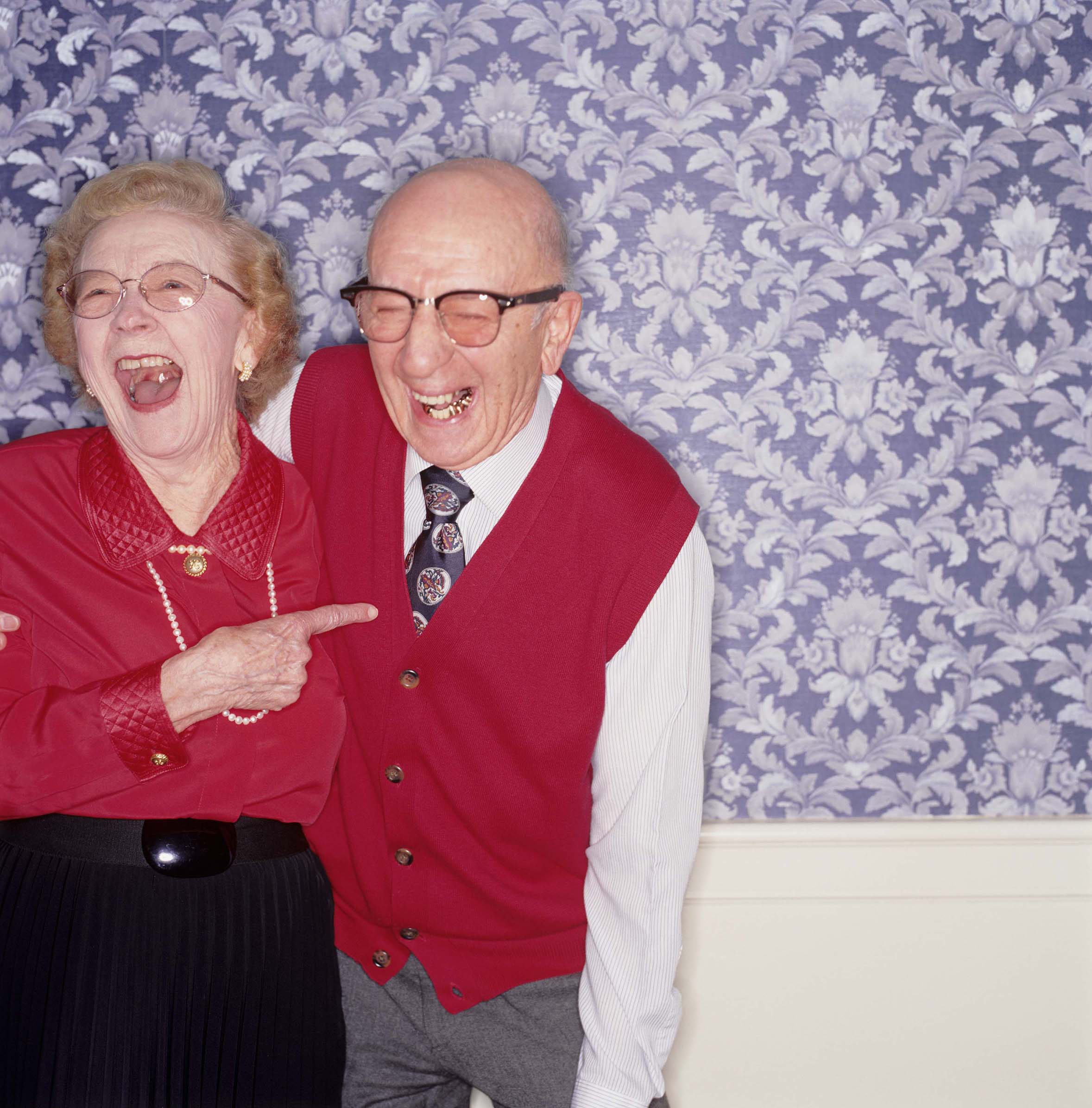 A senior couple laughing arm-in-arm