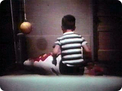 A young boy kicking the doll