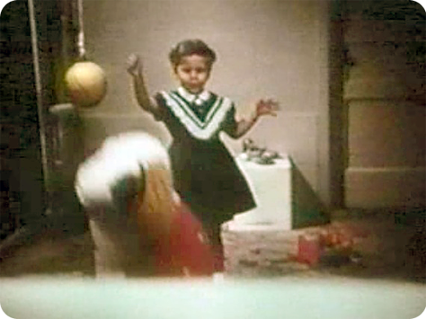 A young girl is punching the doll with her fist.