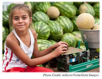 Young girl working at a fruit stand