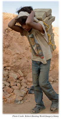 A young boy carrying bricks in Nepal