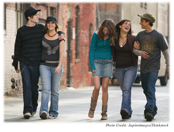 Five adolescents walking and laughing