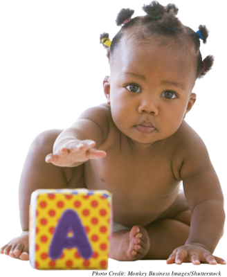 A toddler reaching for a block with an "A" on it