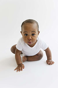 Black baby boy crawling on floor