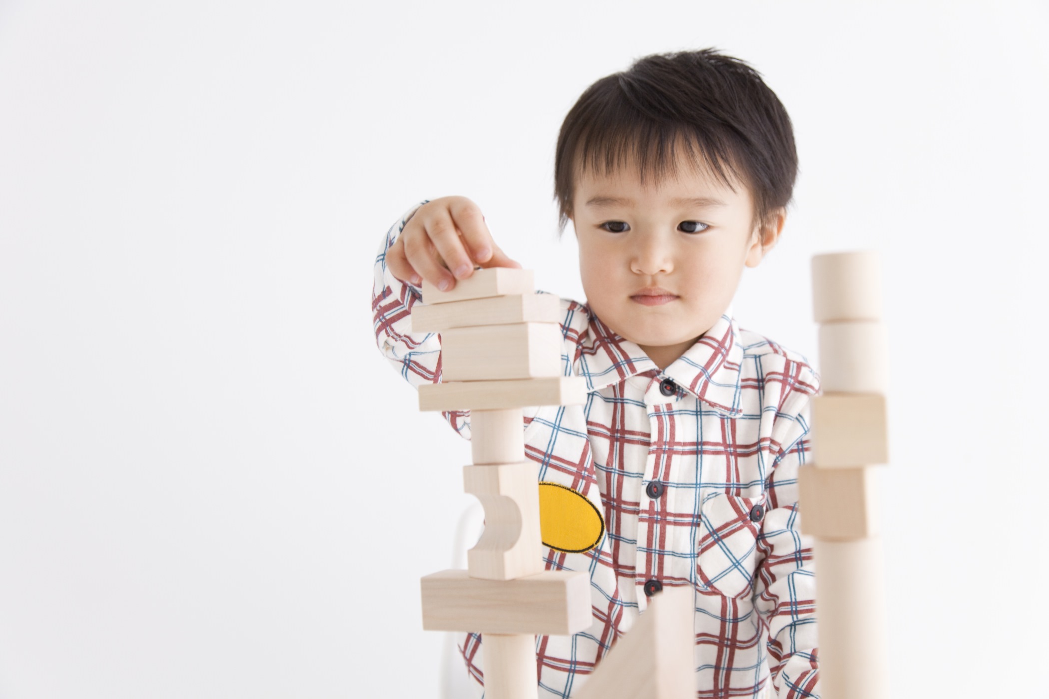A young boy is playing with blocks. He is between 2 and 6 or 7 years old
