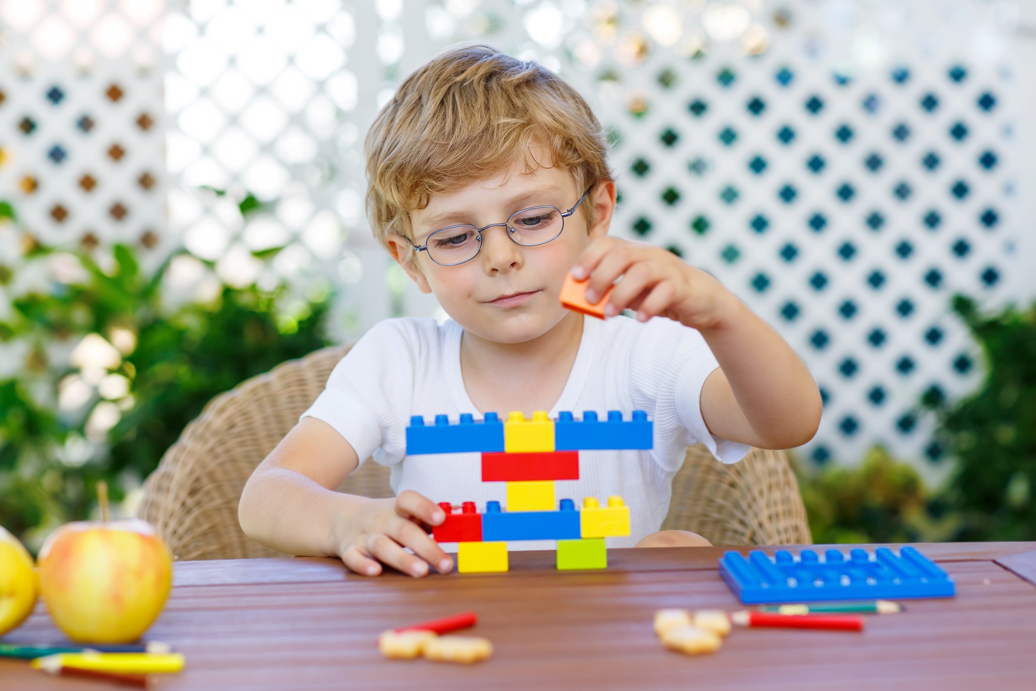 a young boy playing with legos who is 2 to 6 or 7 years old