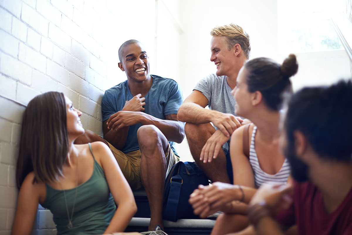 Photo: Show multi-racial group of young adults in conversation