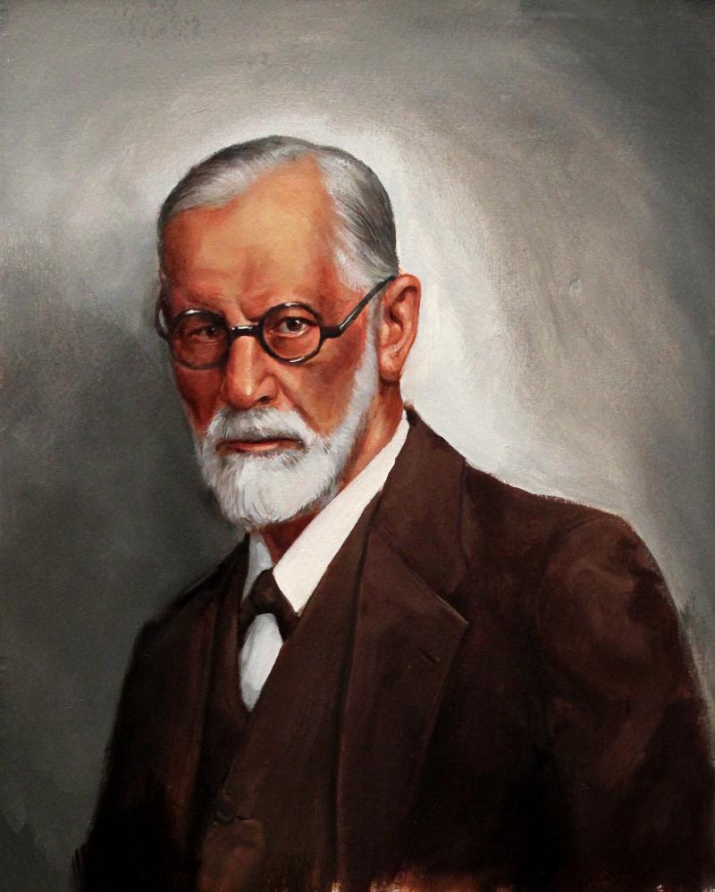 An academic portrait painting of a bearded elderly man in a brown suit and round rimmed spectacles. 