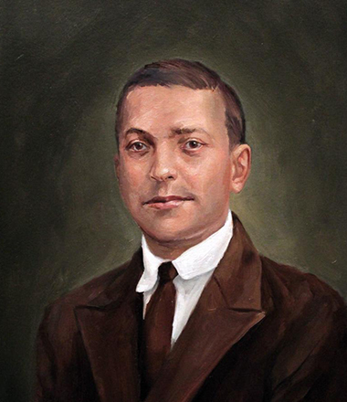 An academic portrait of a young man in a brown suit.