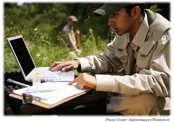 A student with a computer collecting data in the field