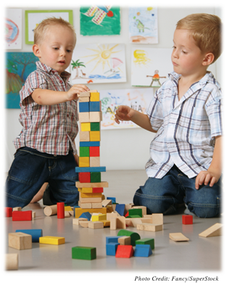 Two boys playing with blocks together