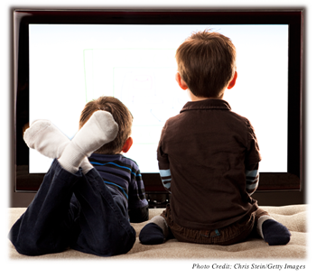 Two young boys staring at a TV screen