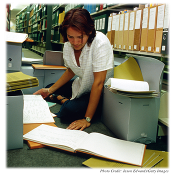 Student looking through documents in a library