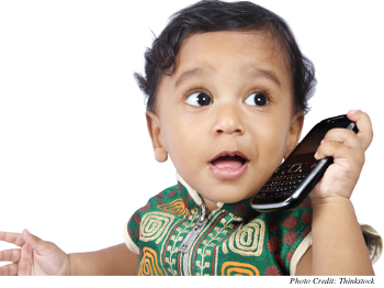 A toddler holding a cell phone as if to talk on it