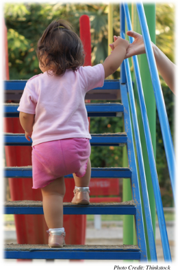 A young child climbing some stairs at a playground