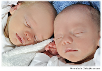 Two newborns sleeping side by side 