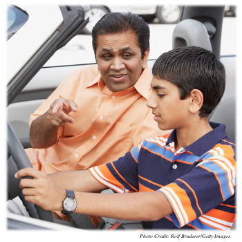An adult teaching a teen how to drive a car