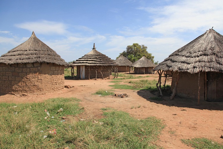 The right image is a group of round clay homes with grass roofs in a dry field of red clay and sparse grass.