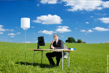 Picture of a man at his desk in a meadow