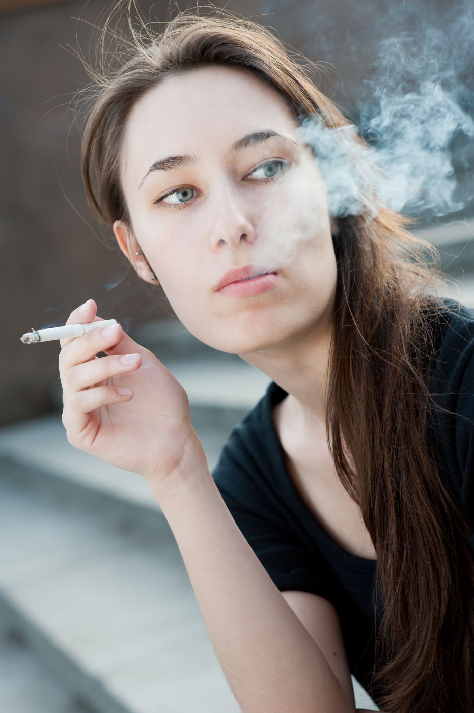 This photo shows a woman smoking a cigarette.