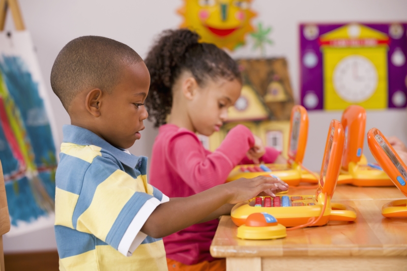 Two kindergarten children play in a classroom that enhances their creative skills.