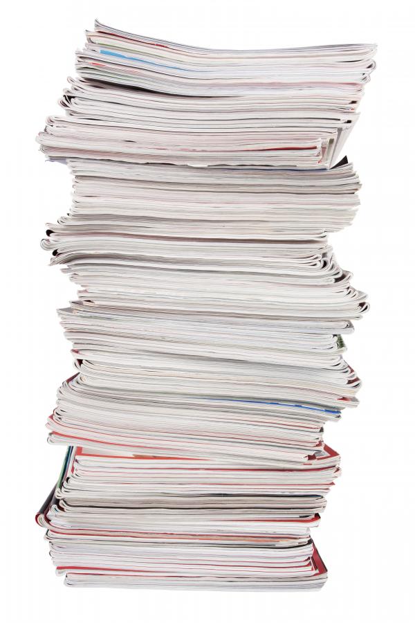 The photo shows a pile of journals signifying the evidence available on personality tests in the workplace.