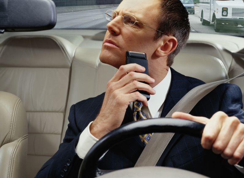 A man shaves while driving.