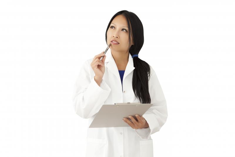 The photo shows a woman thinking while holding a clipboard in her hand. She is probably reporting her level of functioning to assess brain activity.