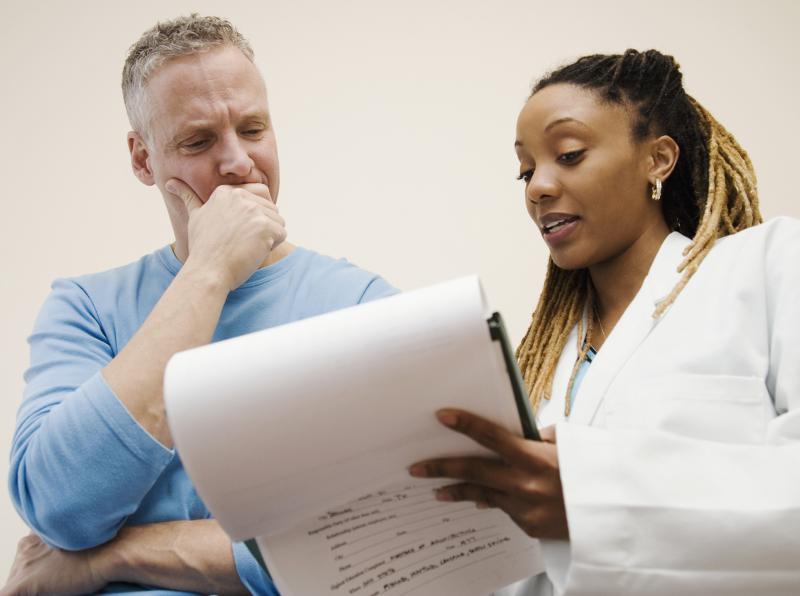 photo of a female, nonwhite medical doctor in white lab coat looking at charts