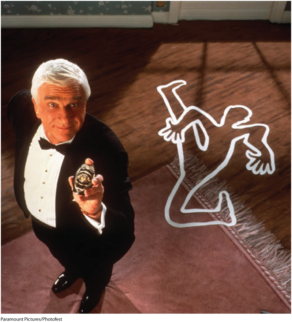 The photo shows a man wearing a suit and a bow tie. He is smiling and showing a badge.  A chalk outline of a dead body is shown on the floor and carpet in the background.