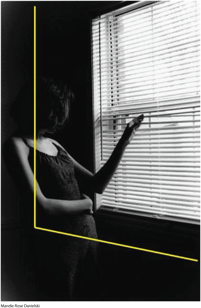 A photo shows a pregant woman inside a room looking through a window. She holds one hand over her stomach as she peers through the blinds. Perpendicular lines are drawn across the photo.