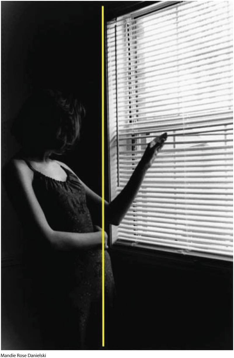 A photo shows a pregnant woman looking outside a window. A single vertical line runs through the center of the photo along the woman's hand and stomach.
      