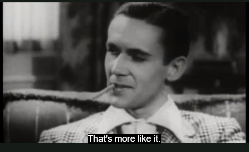 The man is now smiling. He holds a cigarette between his lips. The subtitle reads, That’s more like it.
